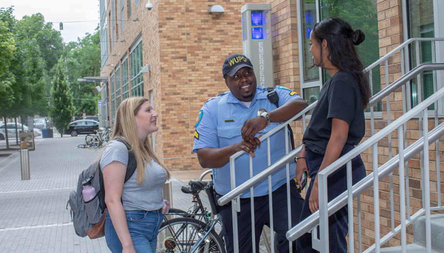 officer talking to students outside the Lofts